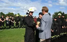 Burmistrz wręcza przedstawicielowi drużyny strażackiej Gołaszewo puchar za zajęcie pierwszego miejsca
