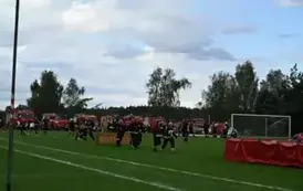 Zdjęcie przedstawia zawodnik&oacute;w biegnących przez przeszkody