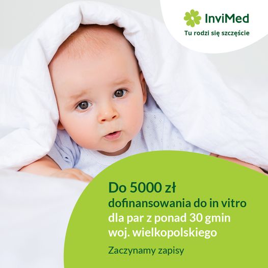 słodki uśmiechnięty niemowlak, leżący na&nbsp;brzuchu