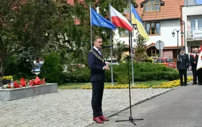 zdjęcie przedstawia burmistrza Mieściska na tle pomnika pamięci mieszkańców Mieściska, którzy oddali życie za ojczyznę, burmistrz przemawia do mieszkańców