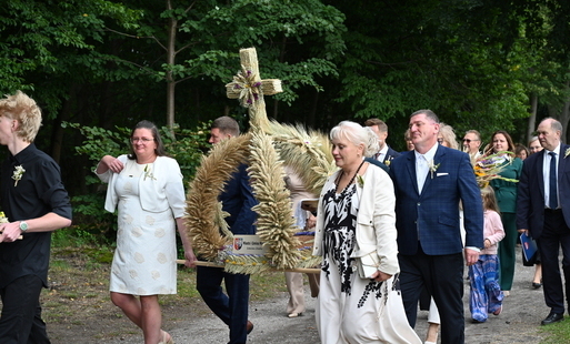 grupa osób niosąca wieniec dożynkowy